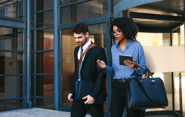 Corporate business professionals walking out of office building