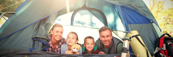 Smiling family lying in the tent