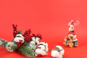 spruce branch, cotton branch, red berries, Christmas decor, red background, toy deer on sleigh