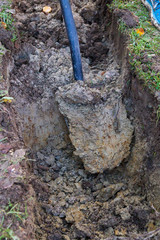 Man digging a ditch with a shovel in autumn