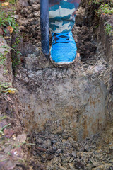 Man digging a ditch with a shovel in autumn