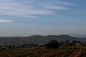 Fototapeta na wymiar sunrise over village,italy,hill.landscape,view,countryside,view,field,agriculture,horizon,autumn,sky,clouds,morning,
