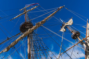 Sailors work with sails at a height on a traditional sailboat