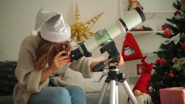 Christmas / New Year's joy with astronomy telescope and cute girl.