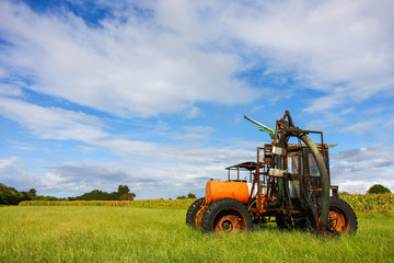 Farm Machine In Field With Light Clouds and Blue Sky