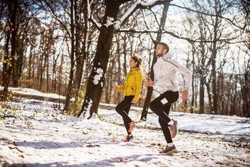 Couple warming up before running in nature. Winter and cold weather.