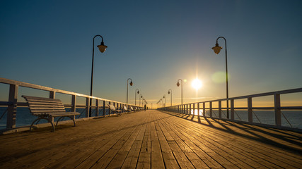 Beautiful and amazing sunrise on the pier at the seaside, Gdynia, Poland.