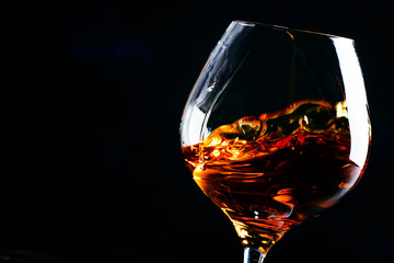 Cognac in a glass, dark background, selective focus