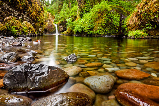 Fototapeta Punch Bowl Falls wzdłuż szlaku Eagle Creek w stanie Oregon z naciskiem na skały na pierwszym planie