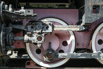 Wheels of the old locomotive of red color and the elements of the drive