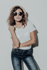 Portrait of young curly latin woman in casual summer clothes in brown hat isolated on white background.