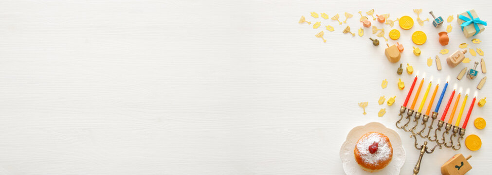 Banner of jewish holiday Hanukkah background with traditional spinnig top, menorah (traditional candelabra) and burning candles.