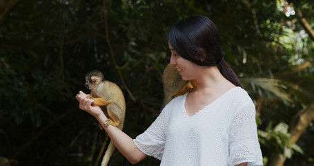 Woman feed Squirrel Monkeys in ishigaki park