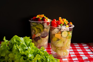 Fruit and vegetable salad in glass bowl on table
