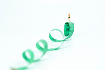 Miniature people running on measure tape. healthy concept