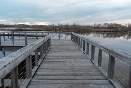 Wood fishing dock over Purgatory Creek at sunset in Autumn