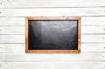 Blackboard in wooden frame on wooden wall