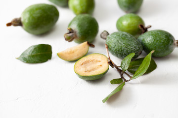 Fresh raw feijoa fruit on white concrete background