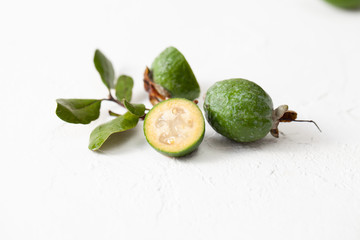Fresh raw feijoa fruit on white concrete background