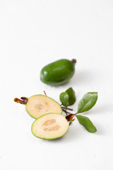 Fresh raw feijoa fruit on white concrete background