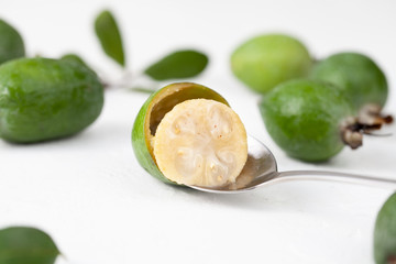 Fresh raw feijoa fruit on a spoon on white