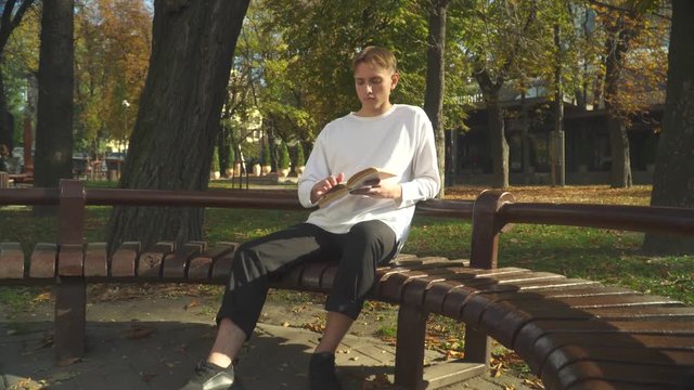 Student is reading a book in the park