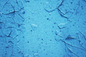 Blue background covered with old paint with cracks