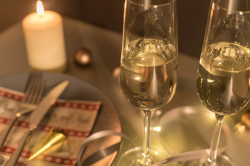sekt im glas mit kerze und teller weihnachten