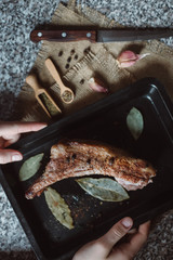 raw meat on in a metal box on dark background. cook cookes the meat