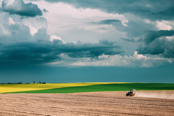 Tractor Plowing Field In Spring Season. Beginning Of Agricultura