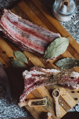  raw meat on wooden cutting board on dark background