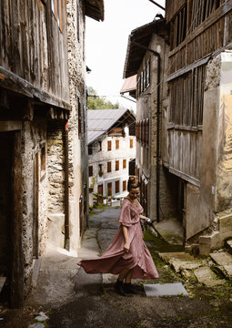 Fototapeta woman walking through old italian village