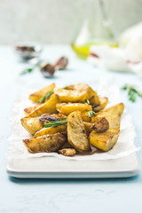 Roasted garlic herbs potato wedges. Selective focus, space for text.