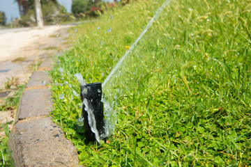 A jet of water pours lawn from the irrigation system. Advertising of the automatic watering system .