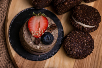 Chocolate dessert with strawberries and blueberries close-up. Cake and biscuits on the table..