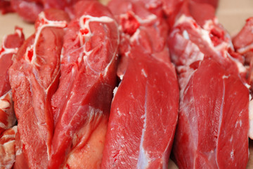 Pieces of fresh raw meat on counter in butcher shop
