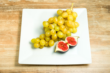 Fresh ripe figs and grapes in a bowl.