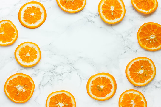 Fresh orange slices on white marble background top view
