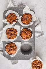 Healthy vegan berry muffins in a baking dish on a white background.