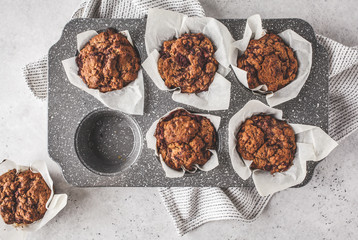 Healthy vegan berry muffins in a baking dish on a white background.
