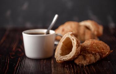 Cup of coffee with croissants on a wooden table