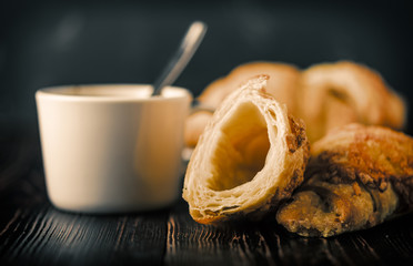 Cup of coffee with croissants on a wooden table