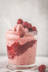 Vegan breakfast raspberry smoothie (ice cream) with berry jam in a jar.