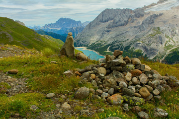 Cumulo di pietre con sullo sfondo il lago Fedaia e la Marmolada
