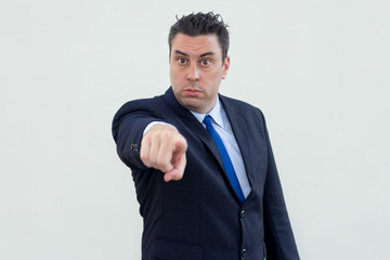 Confident businessman pointing with index finger at camera while choosing you. Serious middle-aged man in suit gesturing hand. Recruitment concept