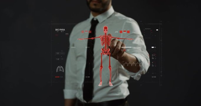 Close up of the male bioengineer or doctor of future examining futuristic health care system and medical data of a human as 3D hologram in the air.