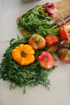 Heirloom tomatoes and carrots on cutting board
