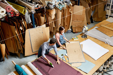 Colleagues Working At Workbench In Sofa Workshop