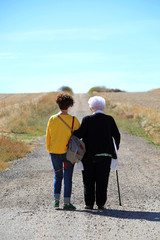 persona mayor con cuidadora caminando en el campo 4M0A5713-f18