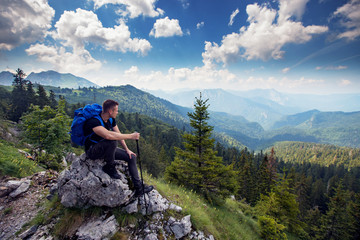 Naklejka na ściany i meble Male hiker with backpack enjoying at breathtaking view